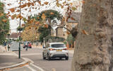 MG 3 drivint through town past trees