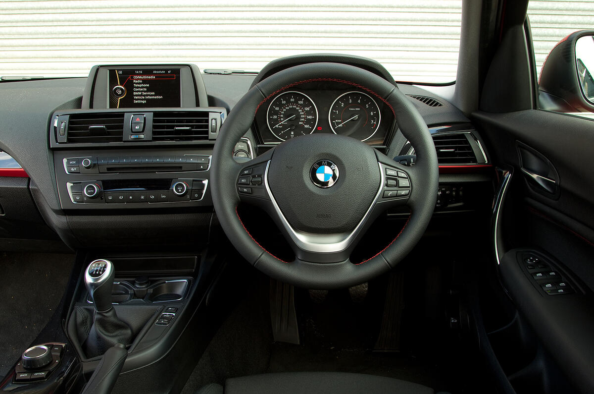 Glossy black fascia trim with red accents lifts the otherwise conservative cabin BMW 1 Series interior