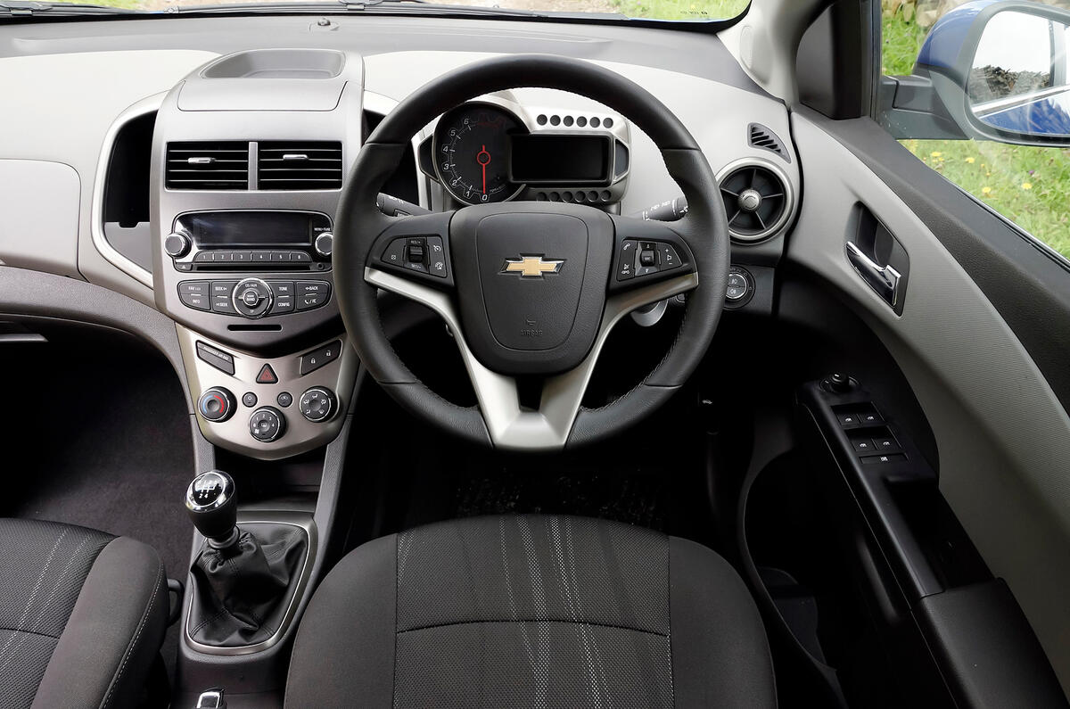 The heavily sculpted steering wheel features switches for the stereo and cruise control Chevrolet Aveo dashboard