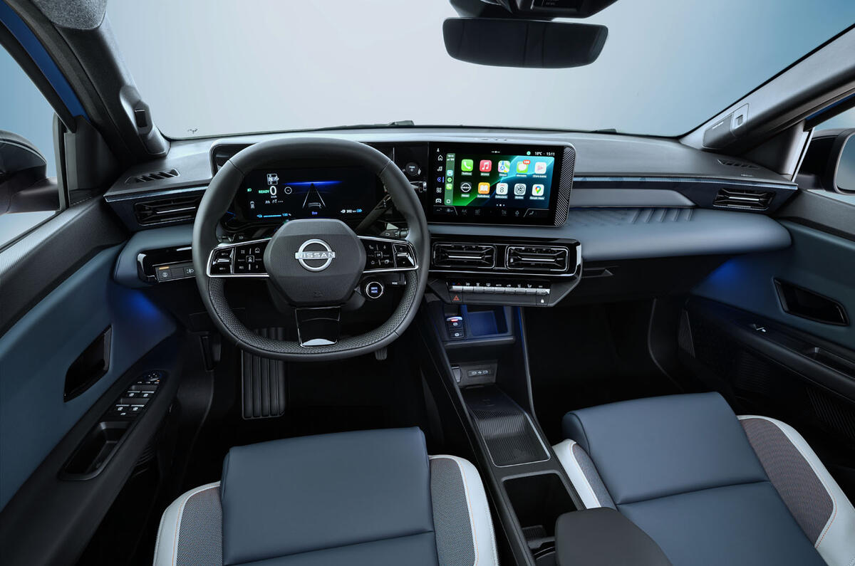 Vue du conducteur sur le tableau de bord complet montrant le volant, l'infotainment centré sur le conducteur, le rétroviseur, l'éclairage d'ambiance bleu sous le tableau de bord, les sièges avant et les rétroviseurs latéraux.