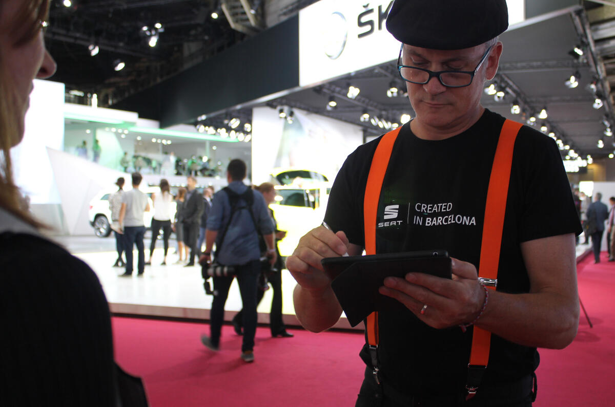 A cartoonist on the SEAT stand draws caricatures on a tablet A cartoonist on the SEAT stand draws caricatures on a tablet