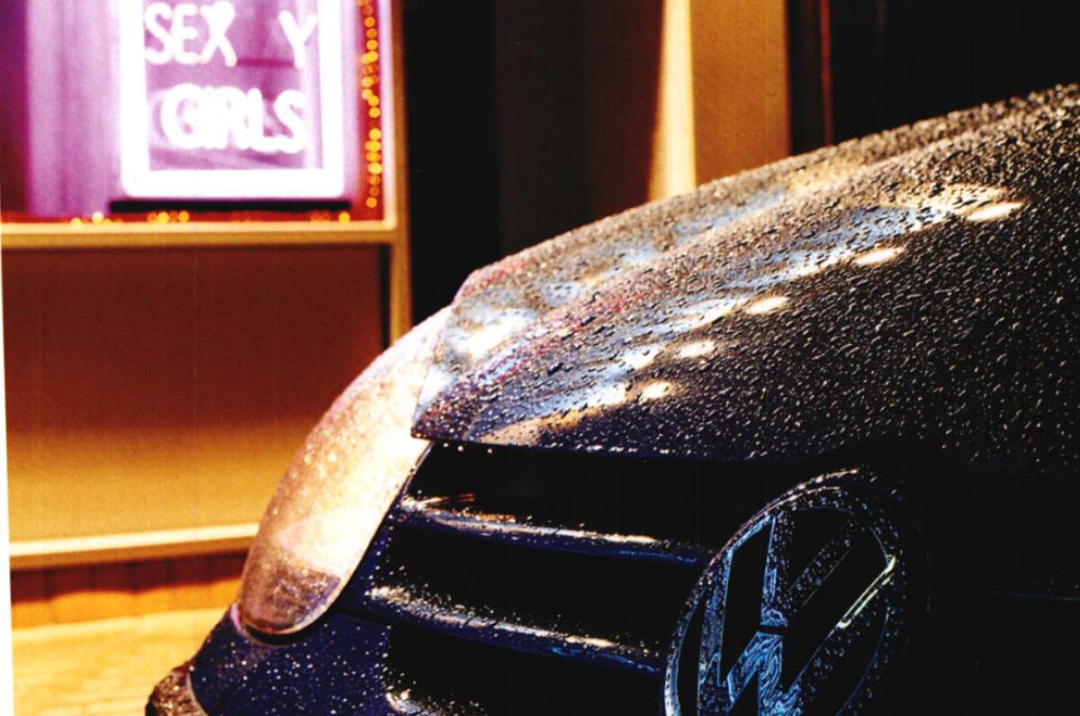 Volkswagen Golf 2005 parked outside exotic dancing club rain