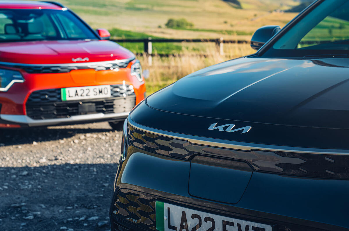 Black Kia Niro in front of red Kia Niro