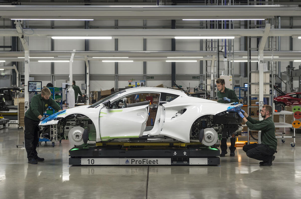 Lotus workers around an Emira body shell at the Hethel factory