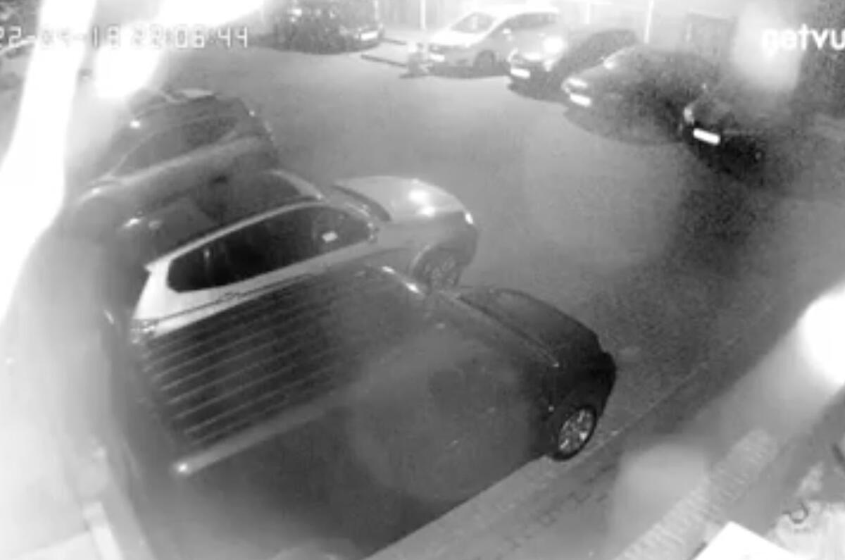 Pic 2 Thief unscrews white car's front plate Pic 2 Thief unscrews white car's front plate