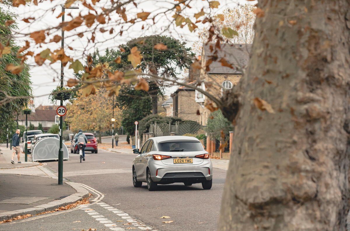 MG 3 drivint through town past trees MG 3 drivint through town past trees