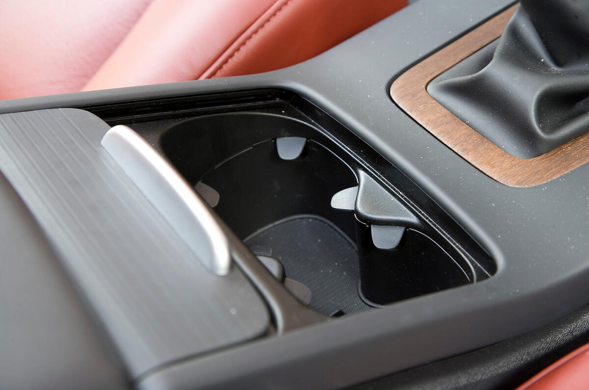 Front centre armrest contains spacious storage box; cupholders sit in front, under neat sliding lid.  Volvo V70 cupholders